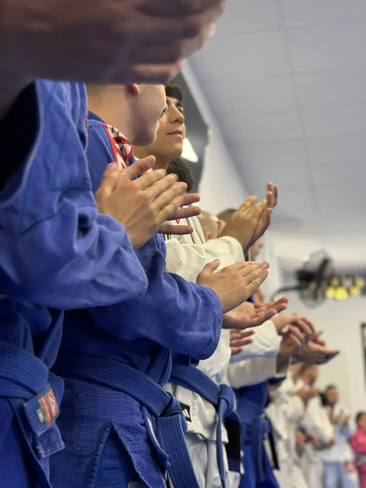 Alumnos de Gracie Barra alineados aplaudiendo al final de la clase
